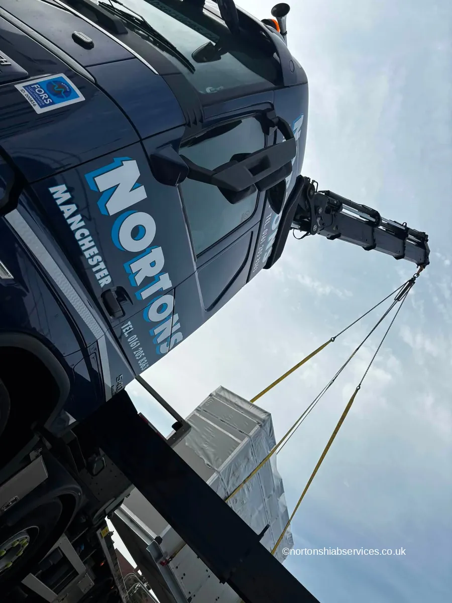 The boom of a Nortons lorry crane seen from below against the sky as it takes the weight