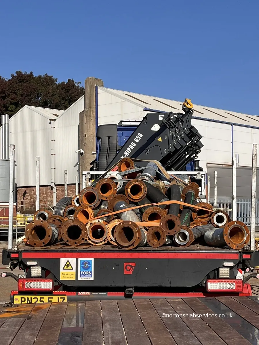 Heavy steel pipework and flanged sections loaded on a Nortons flatbed