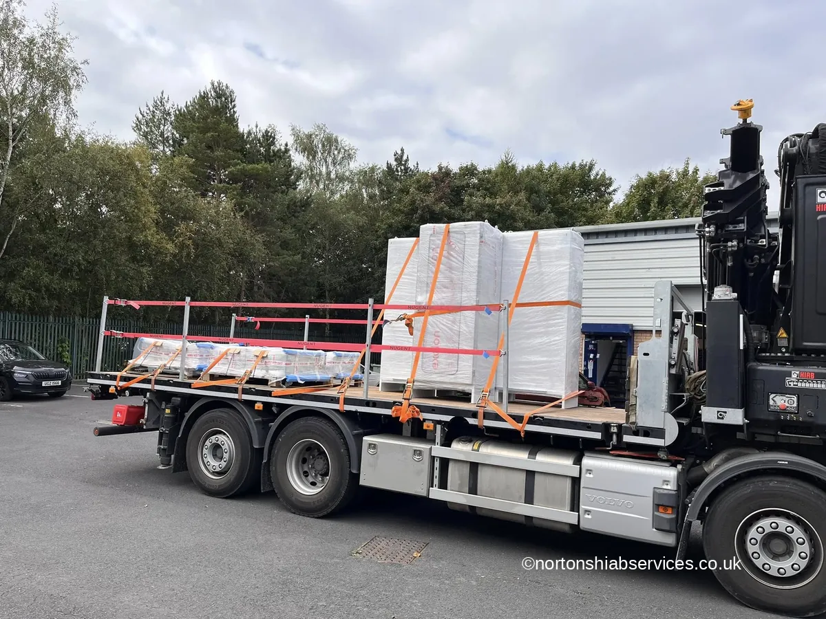 A Nortons rigid loaded with wrapped packs and ladder sections, strapped down