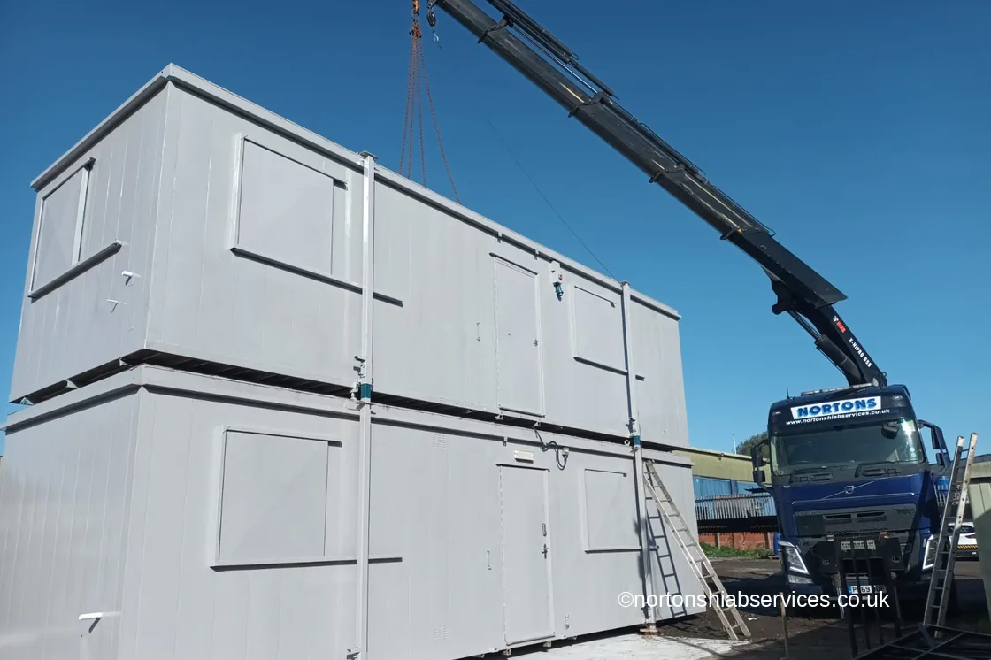 Nortons hiab alongside two stacked portable cabins on site
