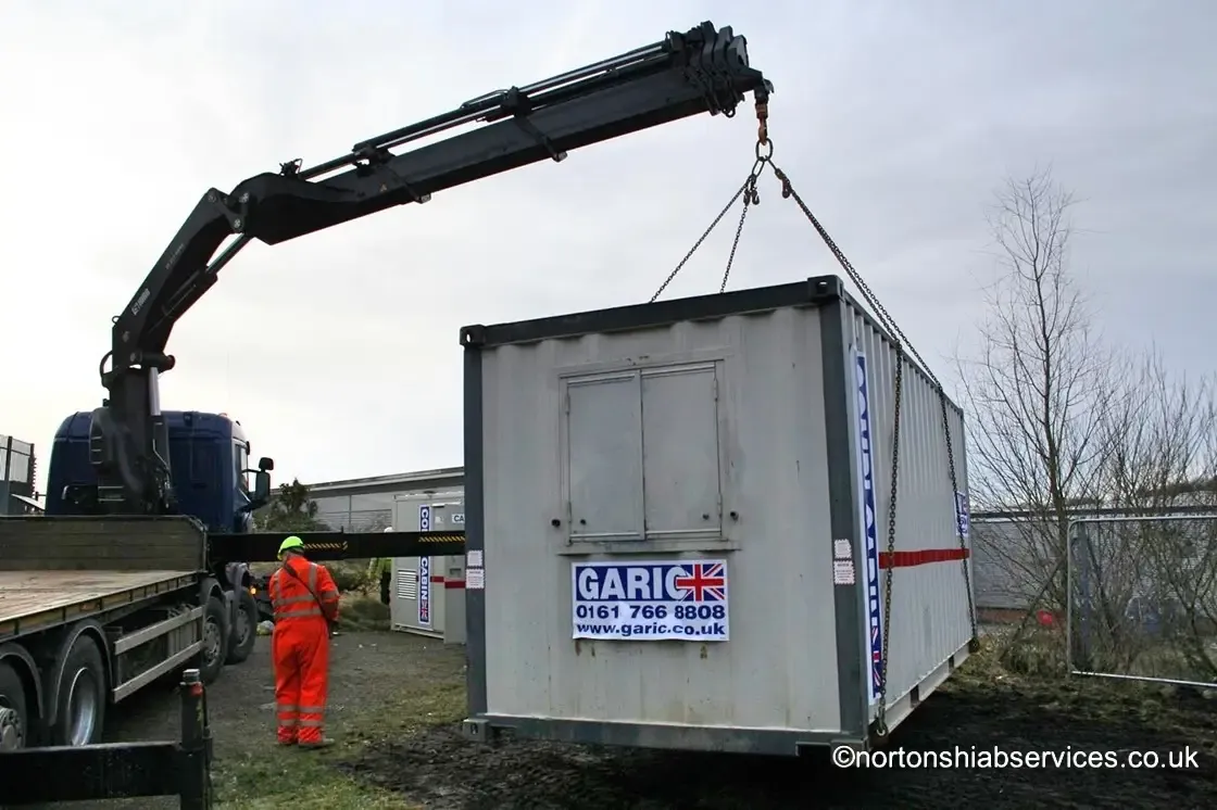Portable cabin loaded on a Nortons hiab lorry ready for transport