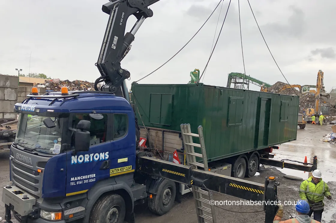 Nortons hiab loading a welfare cabin onto its draw-bar trailer