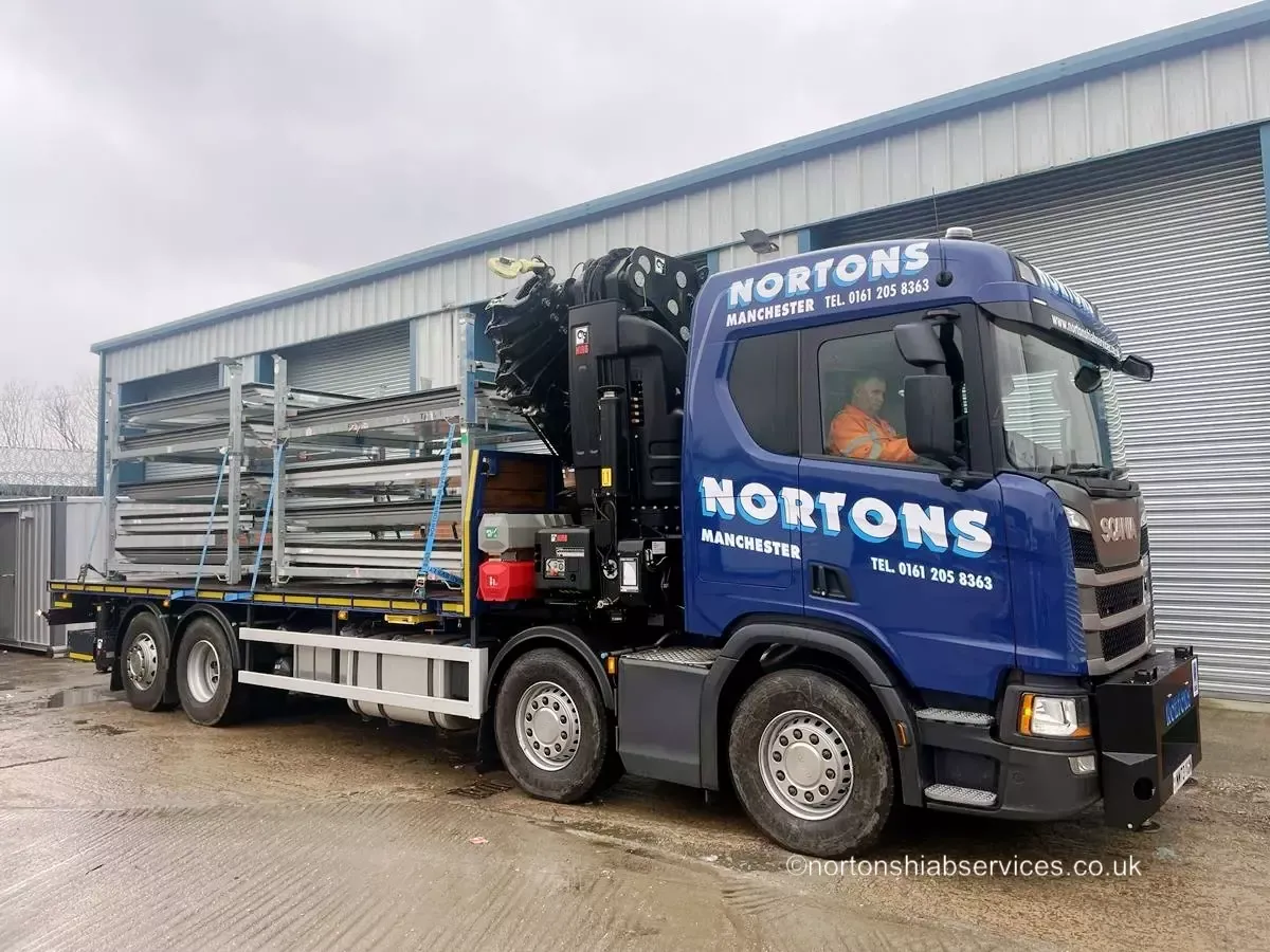 Nortons driver in the cab of an eight wheel hiab lorry at the Manchester yard