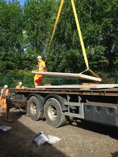 A Nortons crew slinging a long timber panel from the crane on a Manchester job