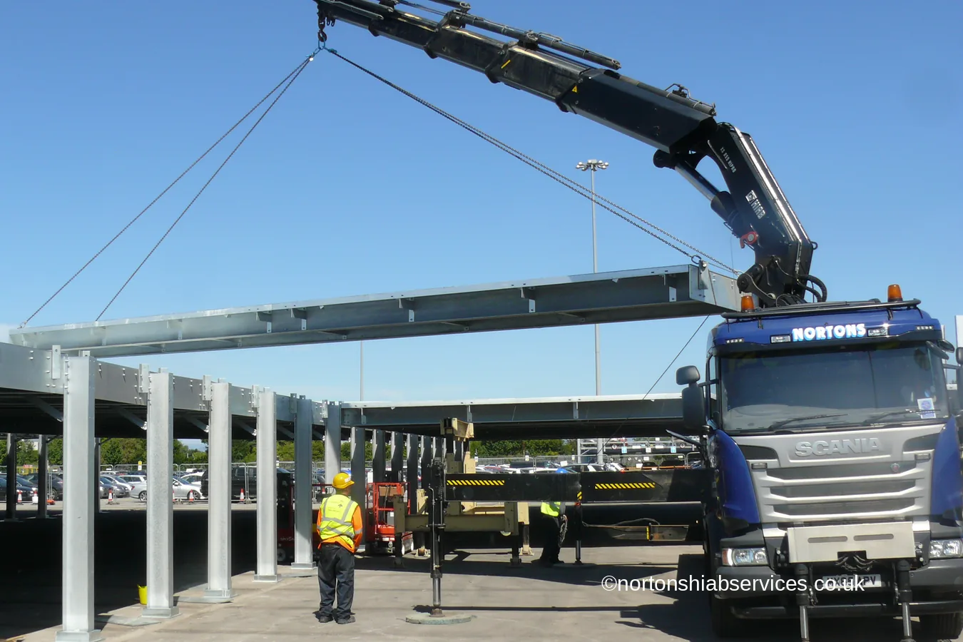 A Nortons hiab lorry lifting a steel beam into a new frame on the Manchester Airport estate