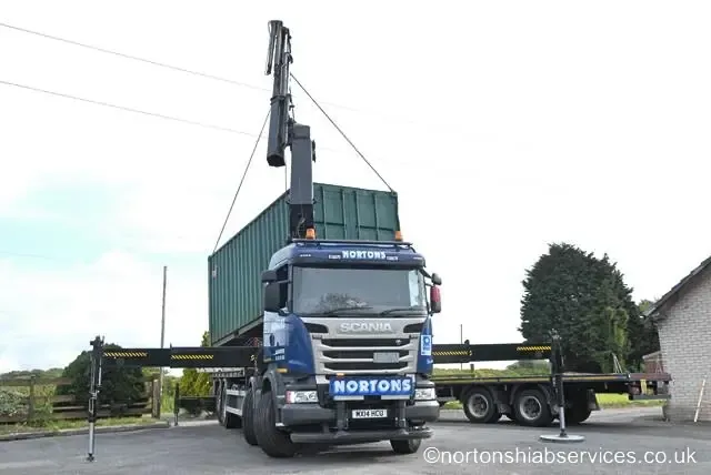 Nortons hiab lorry carrying a shipping container on the road
