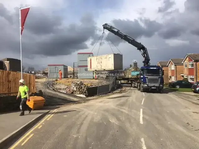 Nortons hiab lifting a loaded shipping container in a street