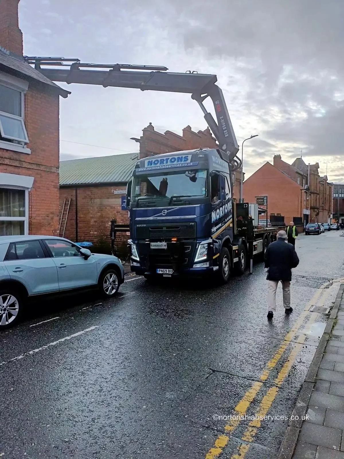 Nortons crane lorry lifting a brewing tank in a city street