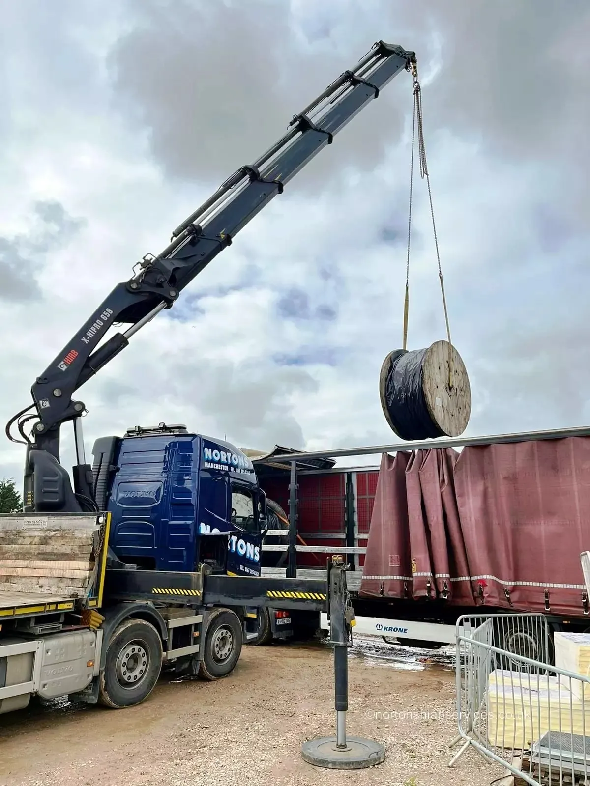 Nortons truck-mounted crane lifting a cable drum from a flatbed