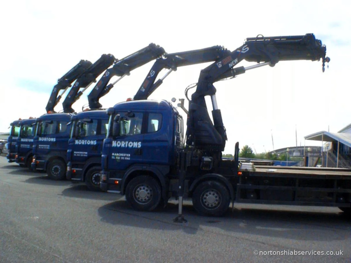A line of Nortons truck-mounted crane lorries with booms folded