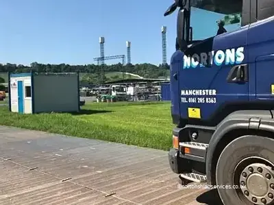 A Nortons Scania standing on temporary trackway laid across the grass at the festival site