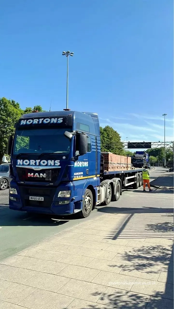 Nortons articulated flatbed lorry loaded and sheeted ready to leave the yard