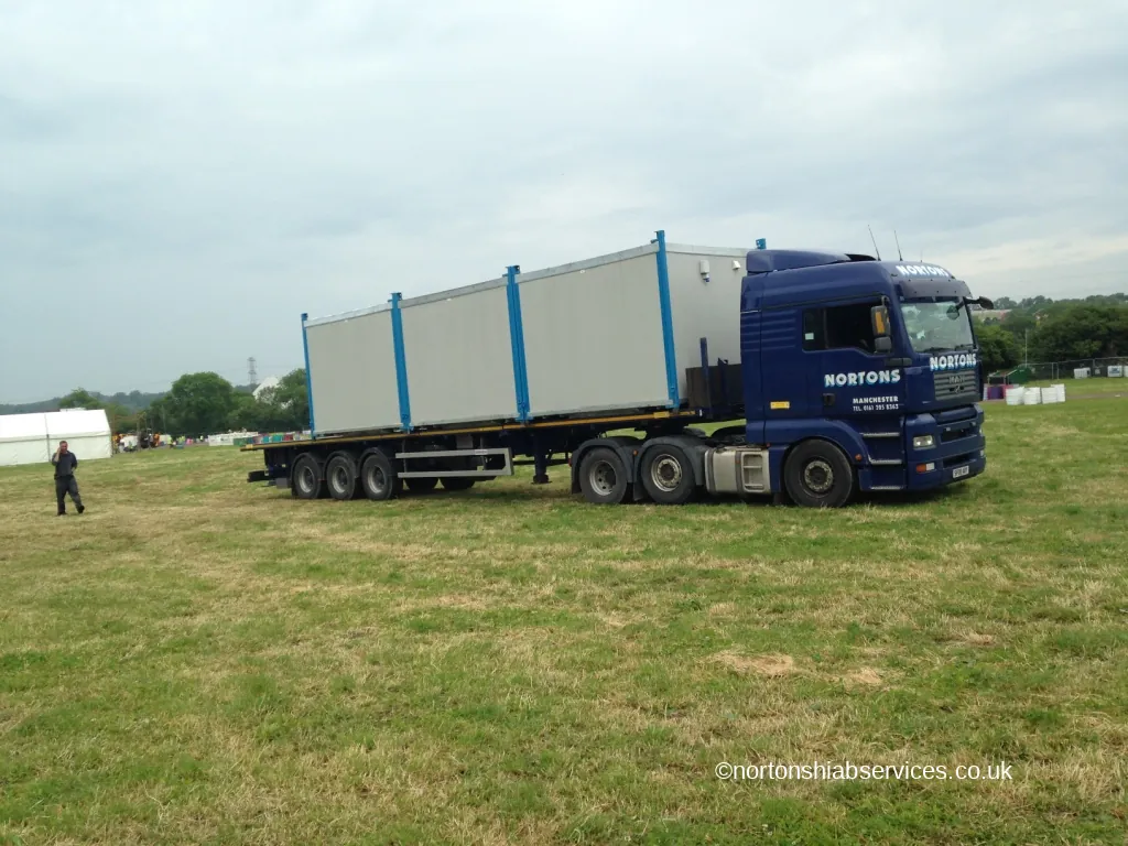 A Nortons lorry crossing a grass field at the Glastonbury festival site