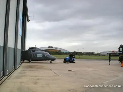Helicopter standing on the apron outside the hangar at Blackpool Airport before loading