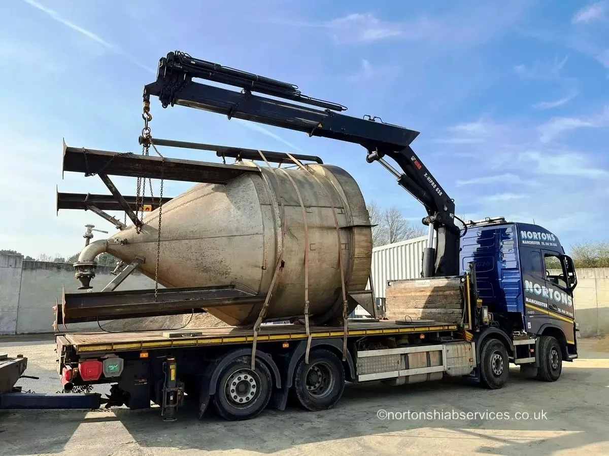 Nortons hiab crane-truck lifting a steel vessel onto a flatbed trailer