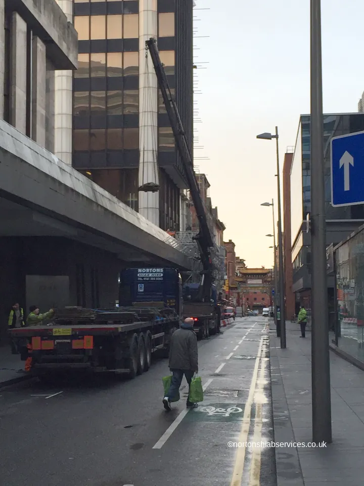 Nortons hiab lorry set up in a Manchester city centre street for a rooftop lift