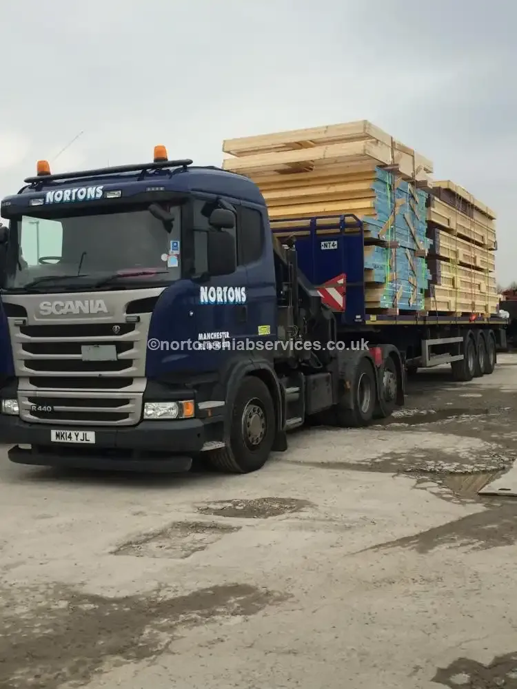 Nortons hiab lorry loaded with timber packs for a construction site delivery