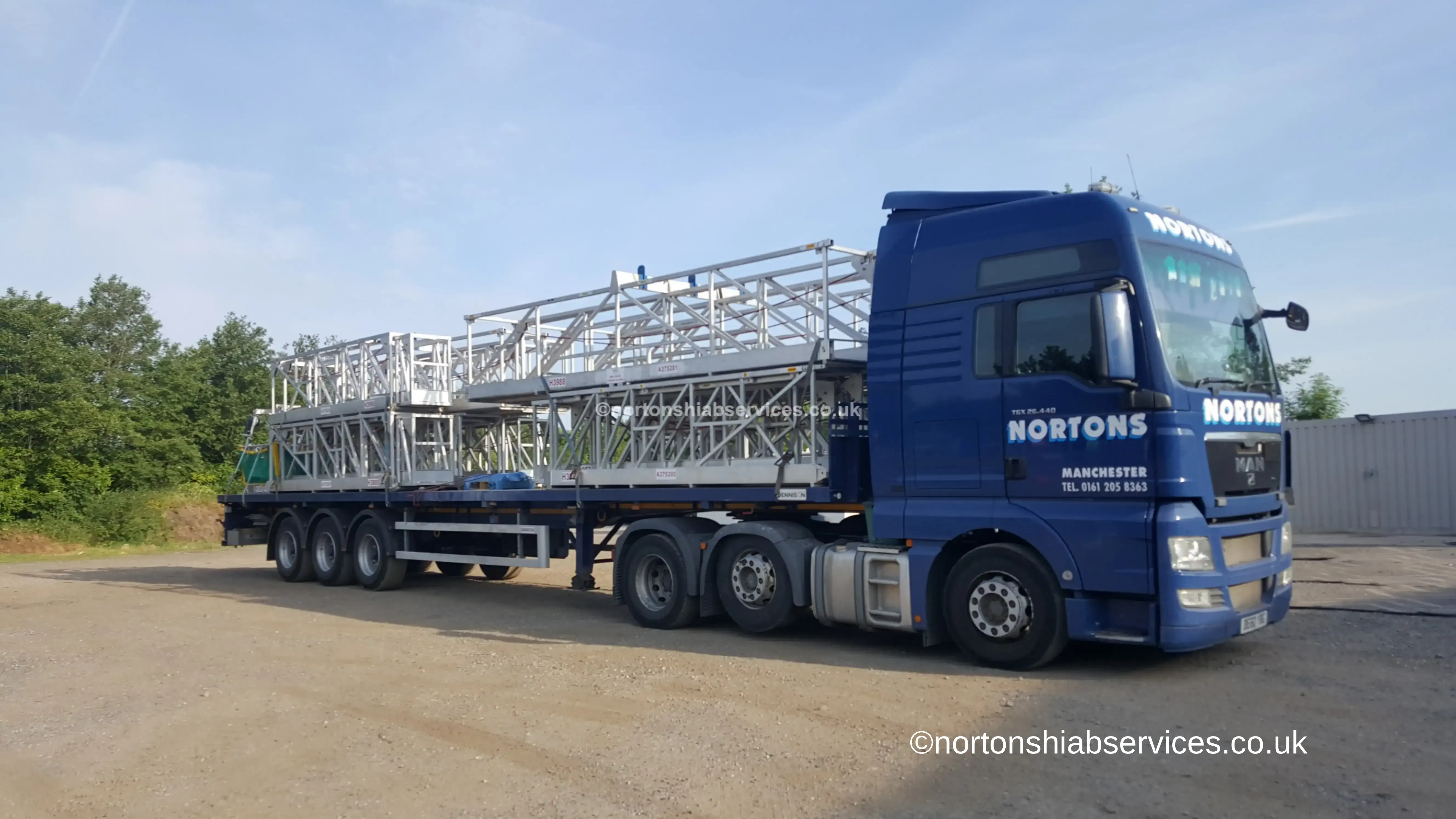 Nortons artic hiab carrying a long load on a flatbed trailer