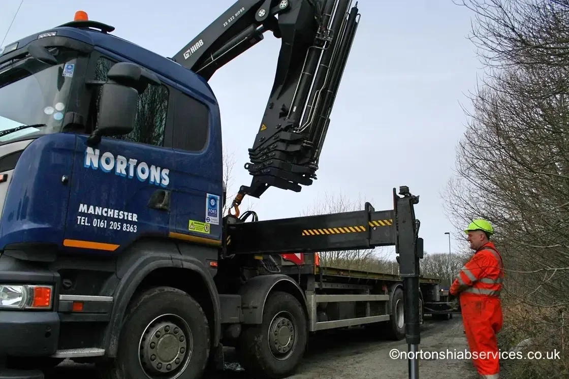 Stabiliser leg and spreader pad set down on prepared ground beside a Nortons hiab