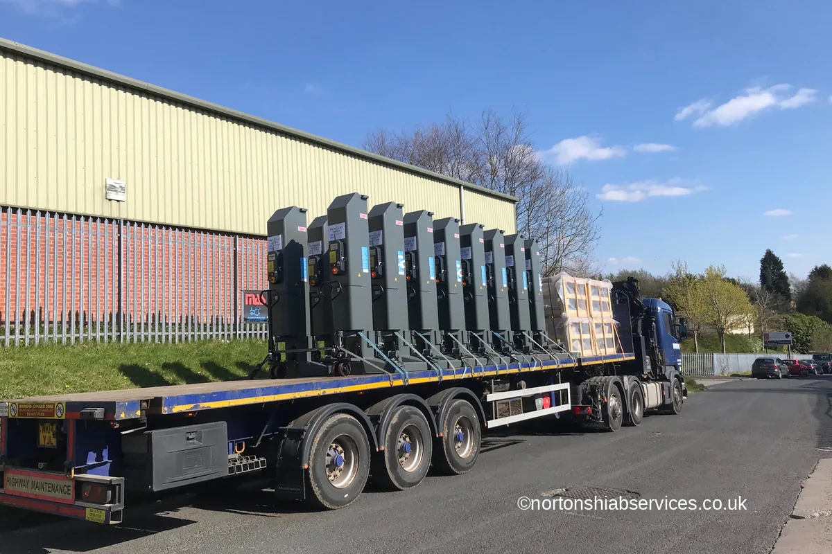Row of garage vehicle lifts loaded on a Nortons extendable trailer