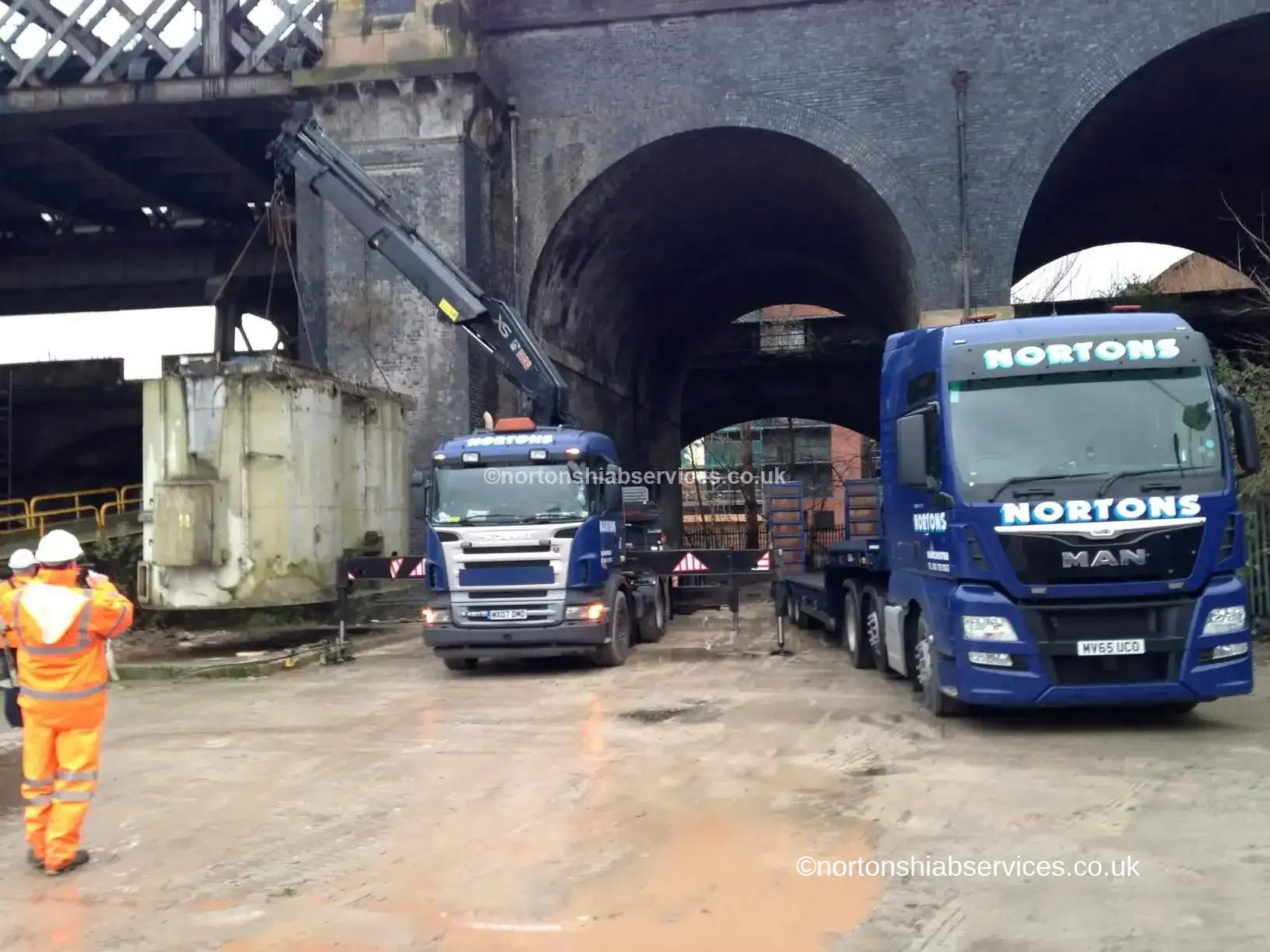 Nortons hiab lifting a cement hopper onto a low loader trailer