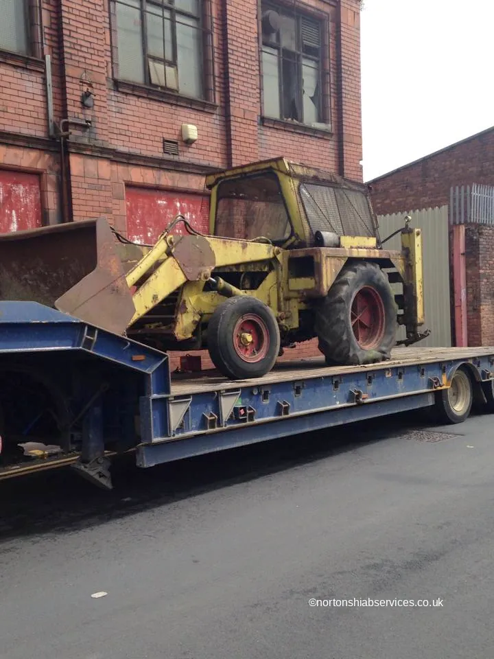Telehandler chained down on the dropped deck of a Nortons low loader trailer