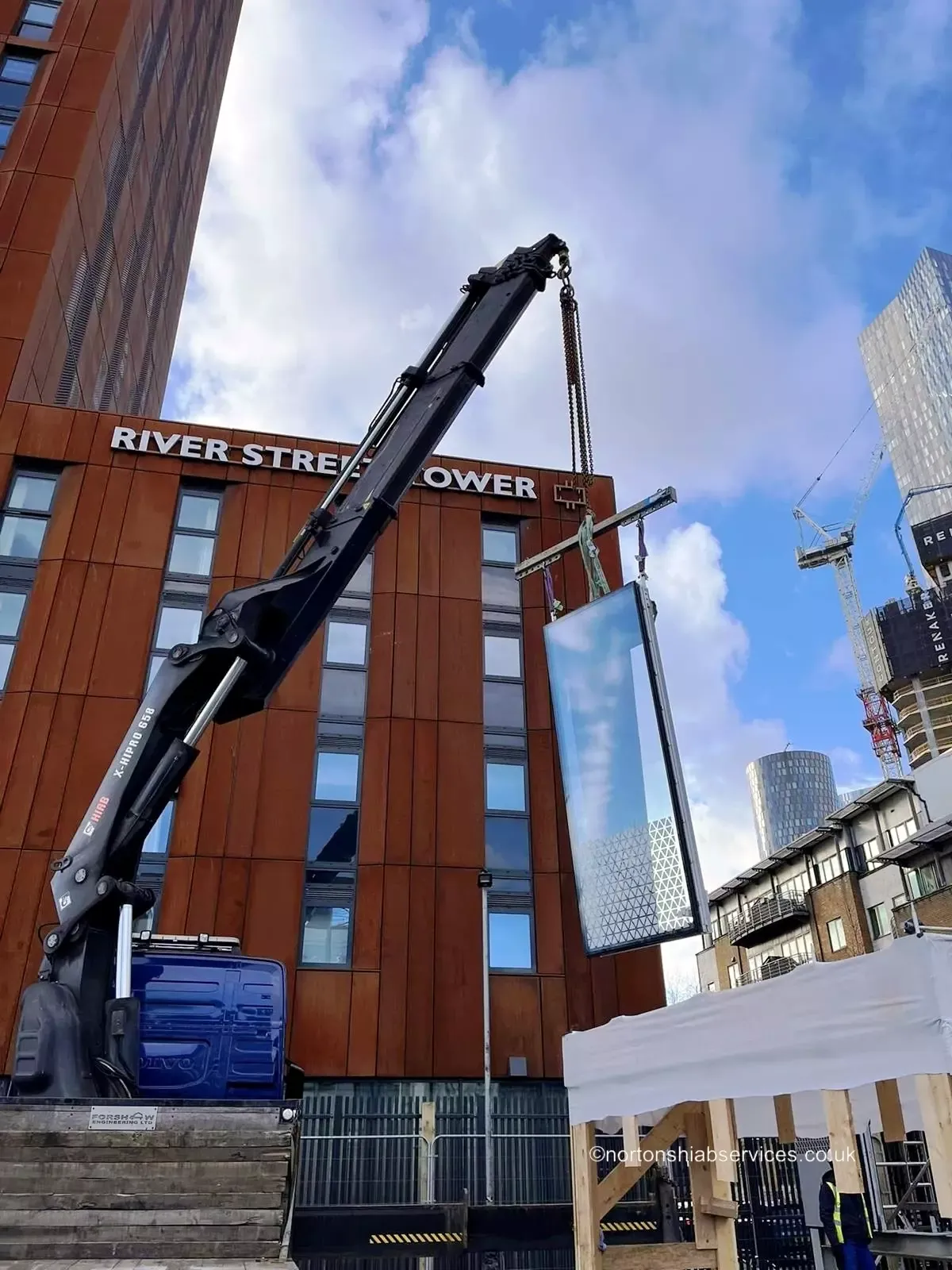 Nortons hiab lifting a panel up the face of River Street Tower in Manchester