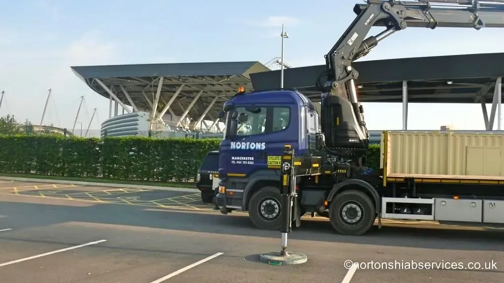 Nortons eight wheel hiab with the crane raised beside the academy roofline in Manchester