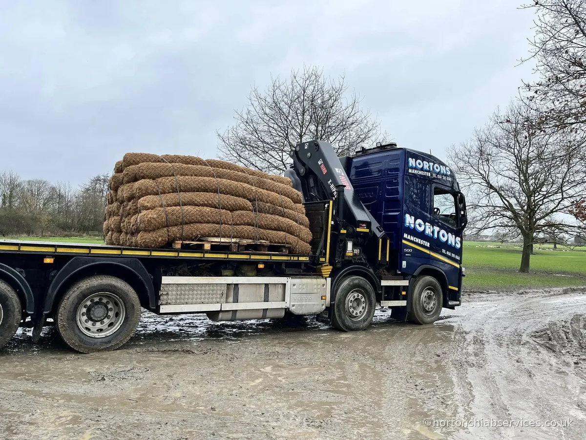 Nortons flatbed lorry delivering a palletised load along an unmade farm track