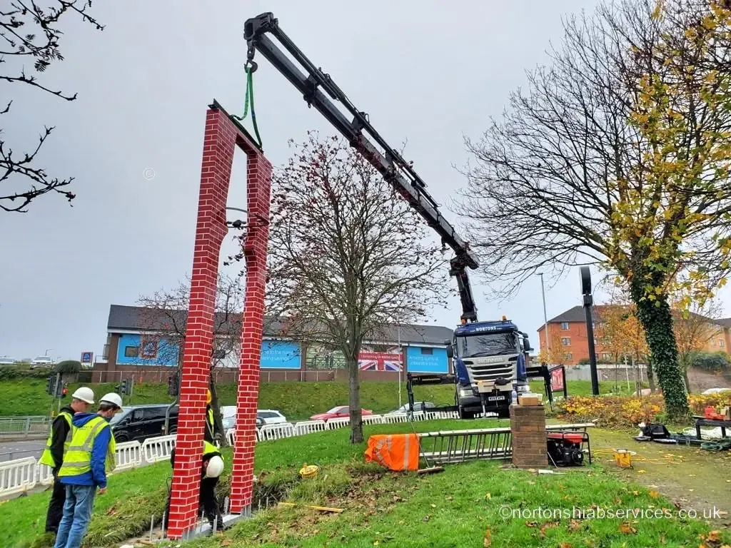 A Nortons hiab installing a tall public gateway column at Barnsley