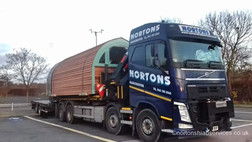 A timber glamping pod loaded on a Nortons trailer for delivery to Bicester