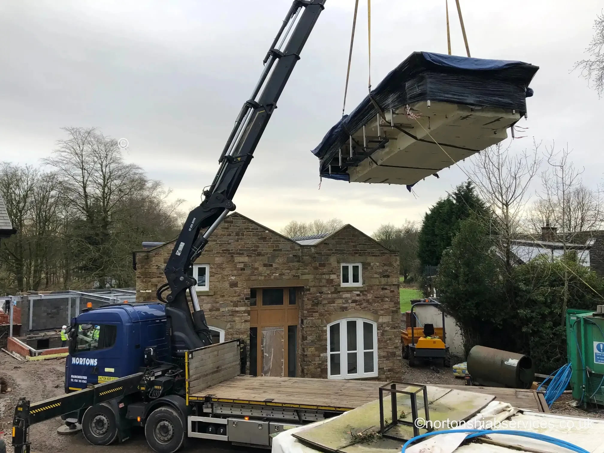 The 855 hiab lifting a fourteen foot wide medical pool at a property in Wigan