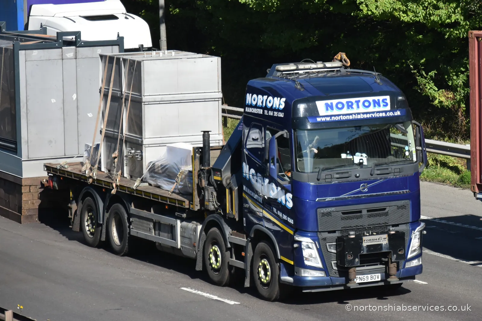 A Nortons rigid carrying a wide load on the M6 with a following vehicle behind
