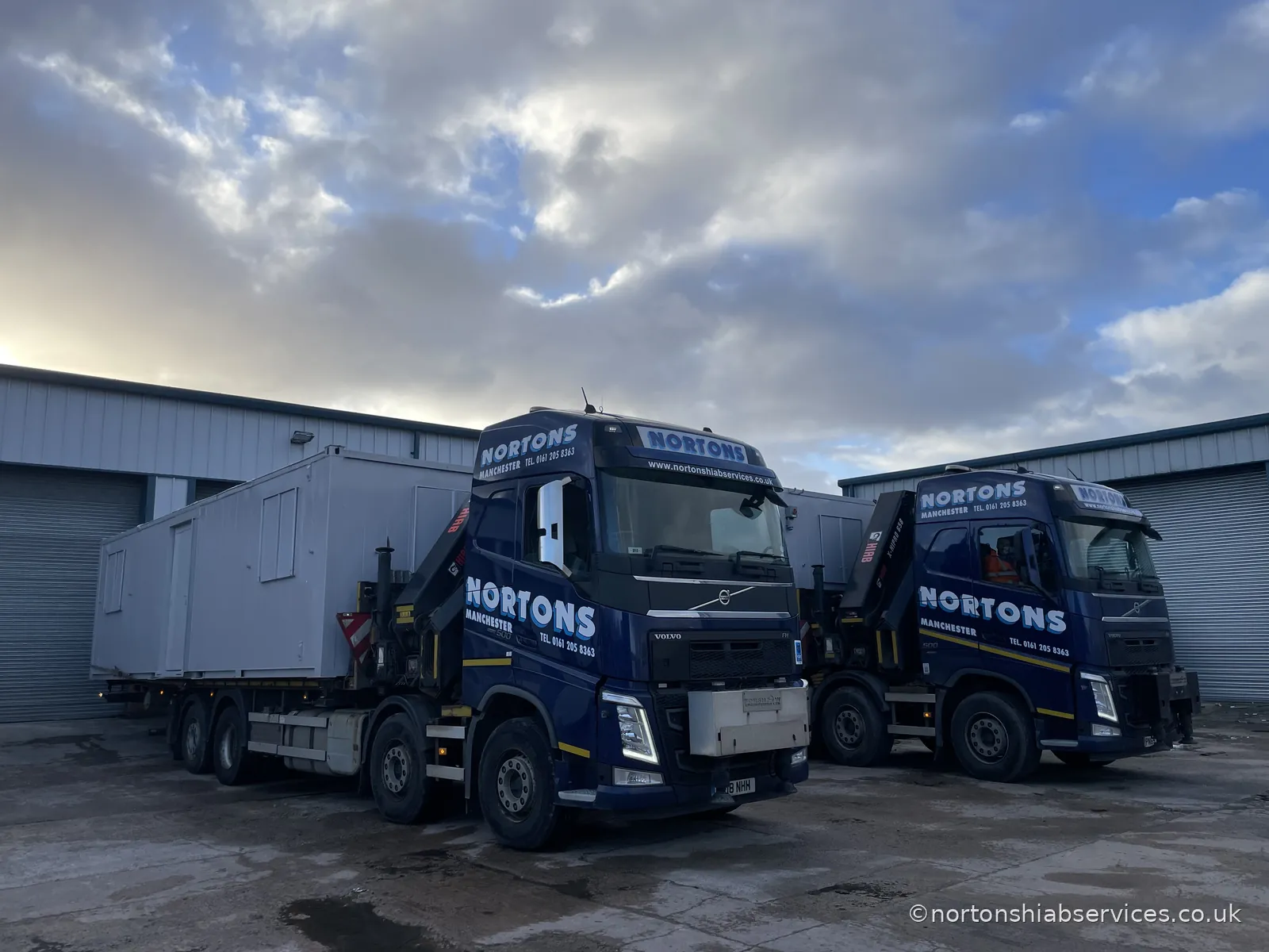 Two Nortons rigids parked together, one loaded with a refurbished cabin
