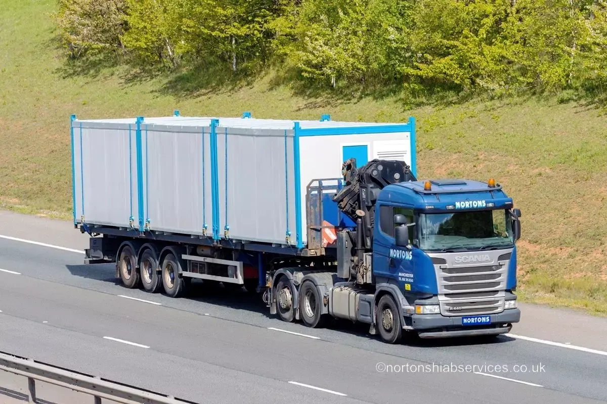 A Nortons Scania artic carrying portable cabins on a motorway