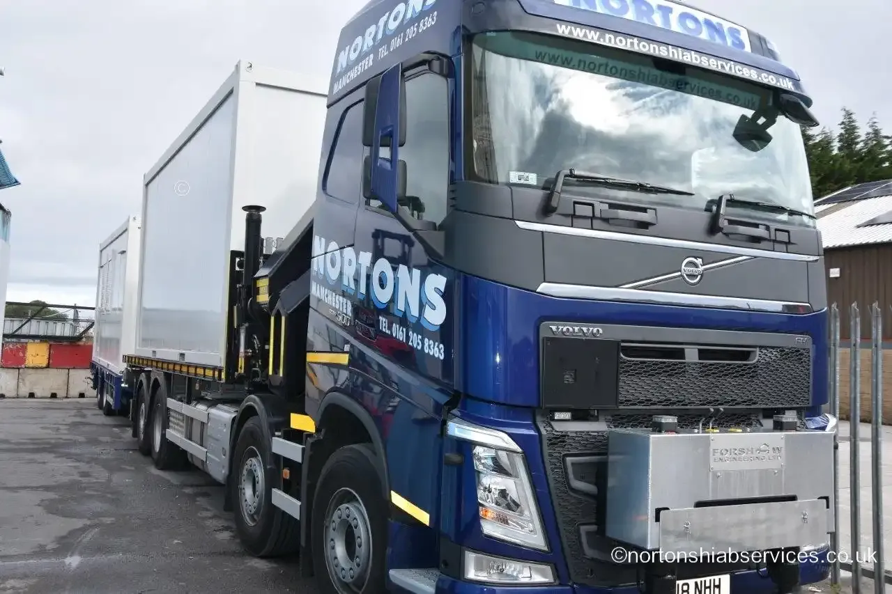 A Nortons Volvo eight-wheel rigid loaded with a white unit parked in a yard