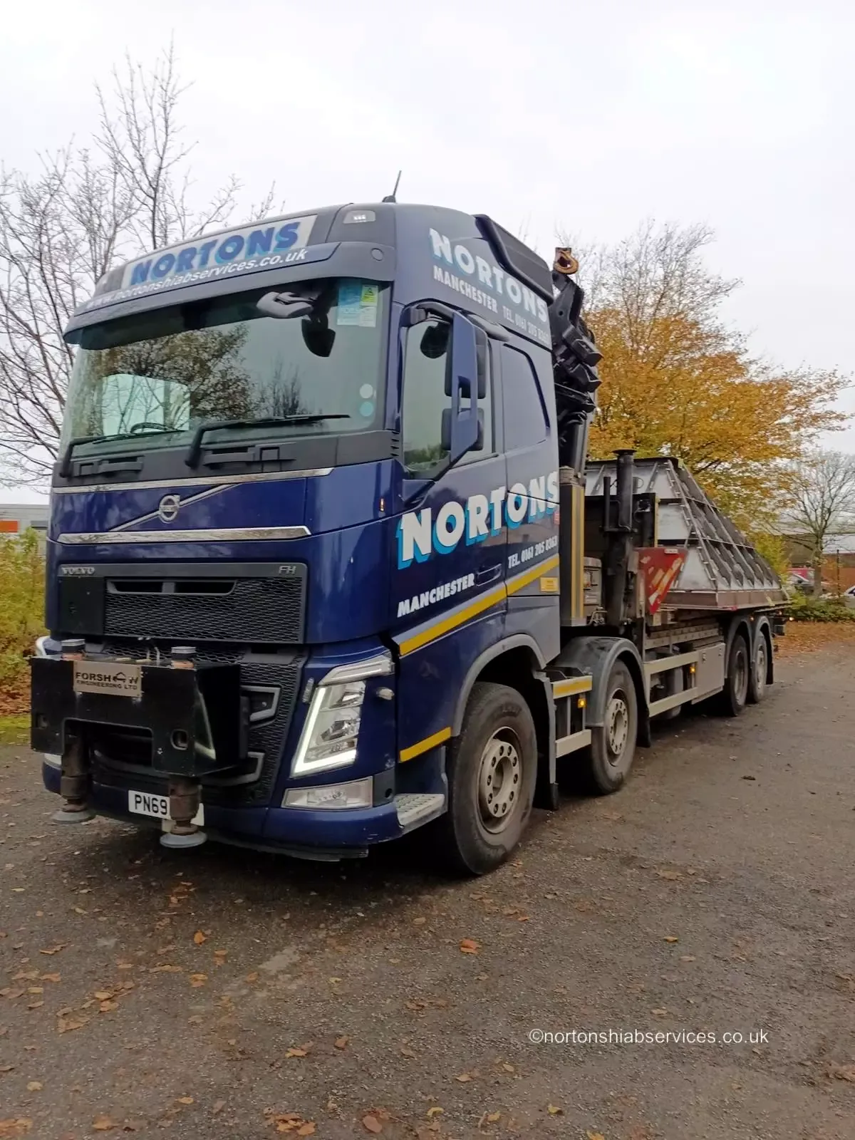 A Nortons Volvo eight-wheel rigid with a rear-mounted hiab parked on a road in autumn