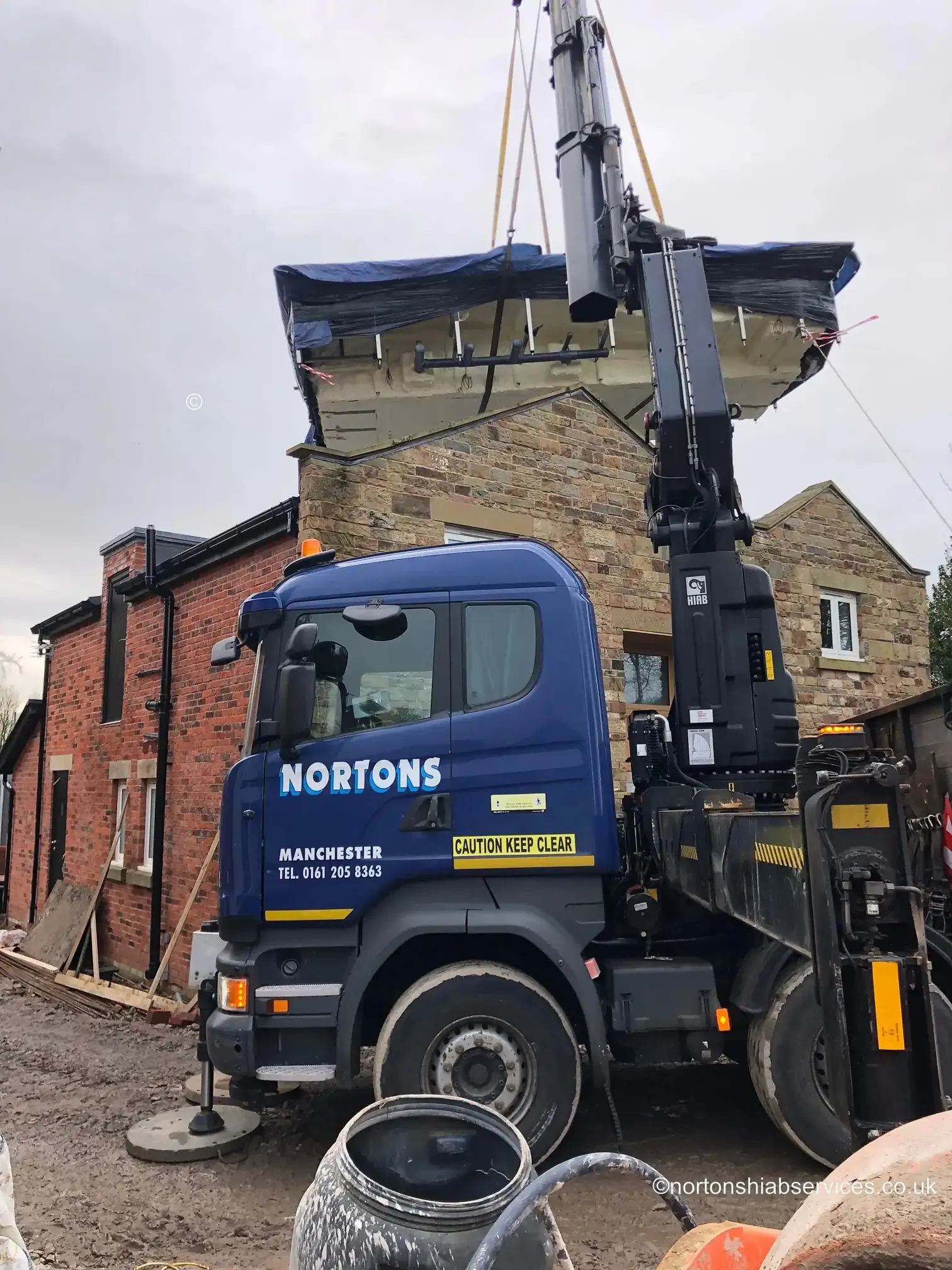 Nortons hiab set up in a narrow space beside a house at Wigan