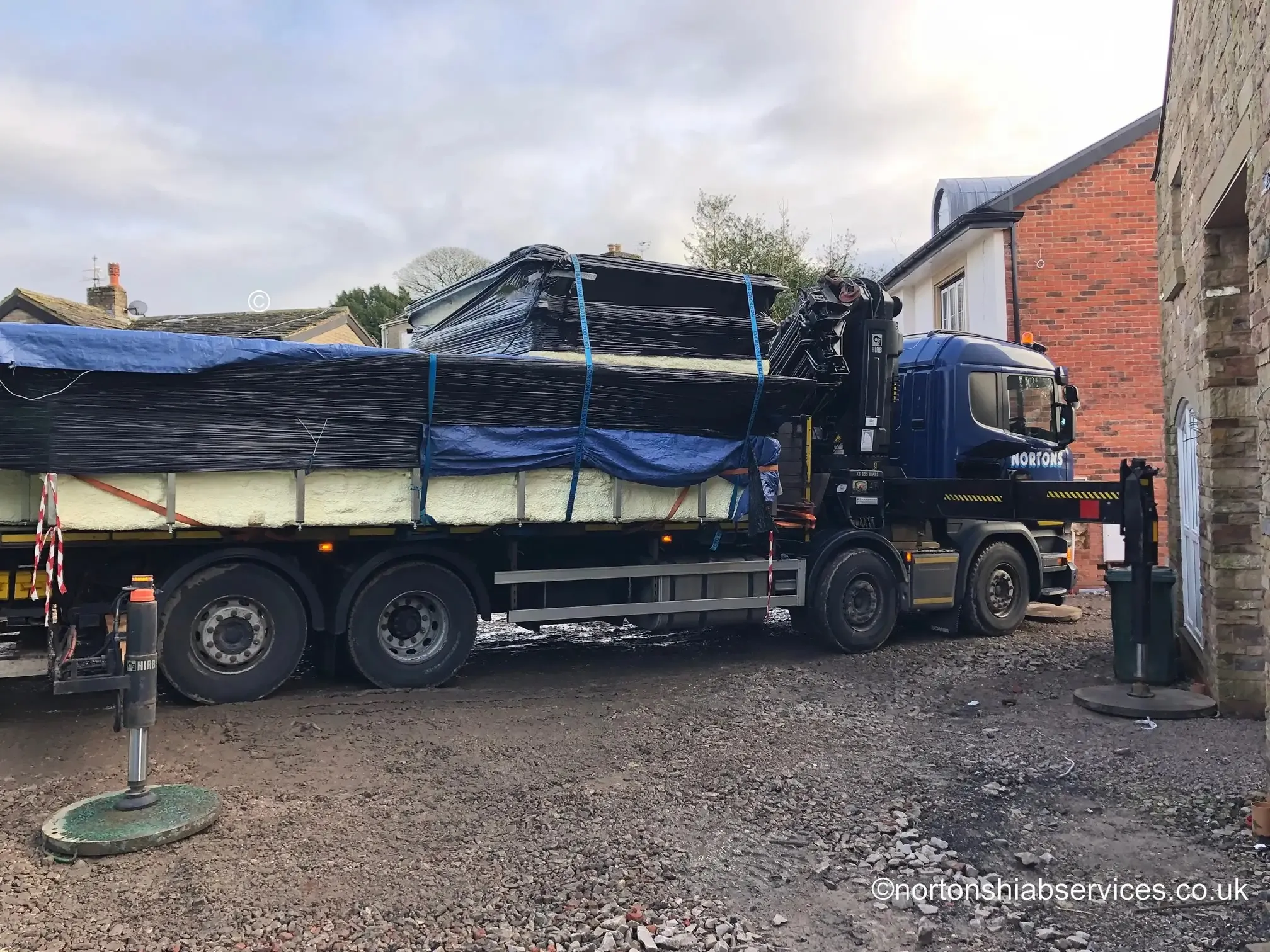 Nortons lorry loaded with a sheeted fourteen foot wide unit at Wigan