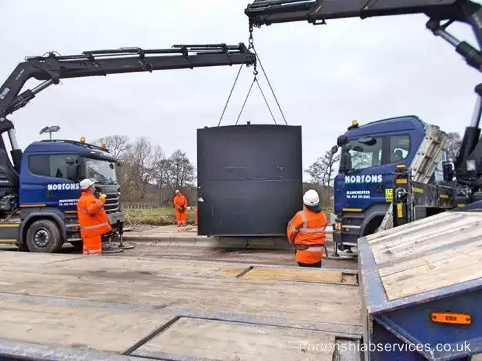 Two Nortons lorry cranes lifting one large fuel tank together in a dual lift