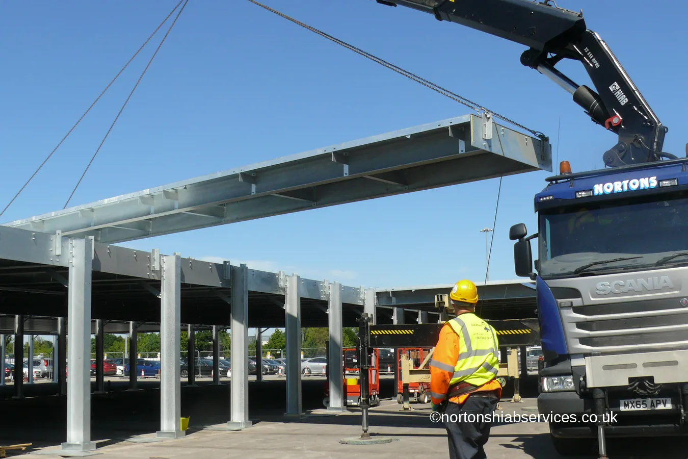 A Nortons crane placing a galvanised steel beam onto a car park frame at Manchester Airport