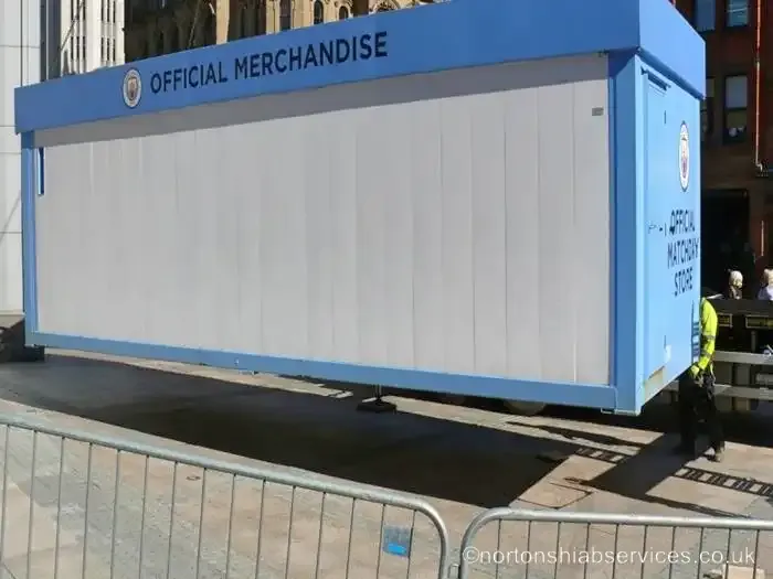 A light blue Manchester City matchday store unit lowered into position in a Manchester street