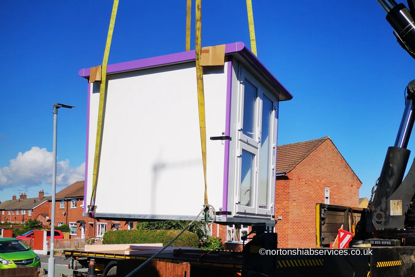 A grooming pod lifted clear of the lorry and swung over a garden fence