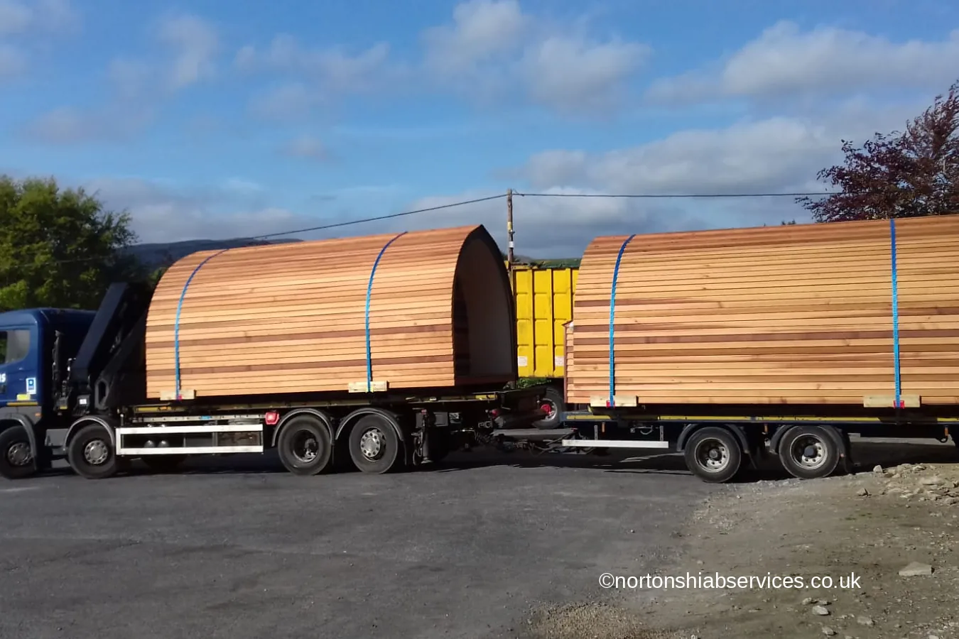 A Nortons wagon and drag loaded with two cedar glamping pods
