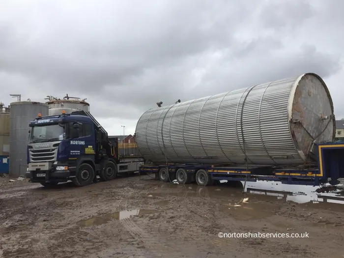 A large stainless steel process vessel loaded lengthways on a Nortons low loader