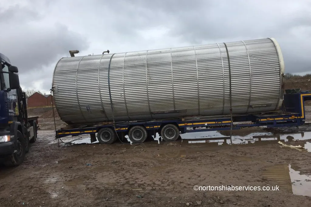 A large steel silo loaded and strapped on a Nortons trailer