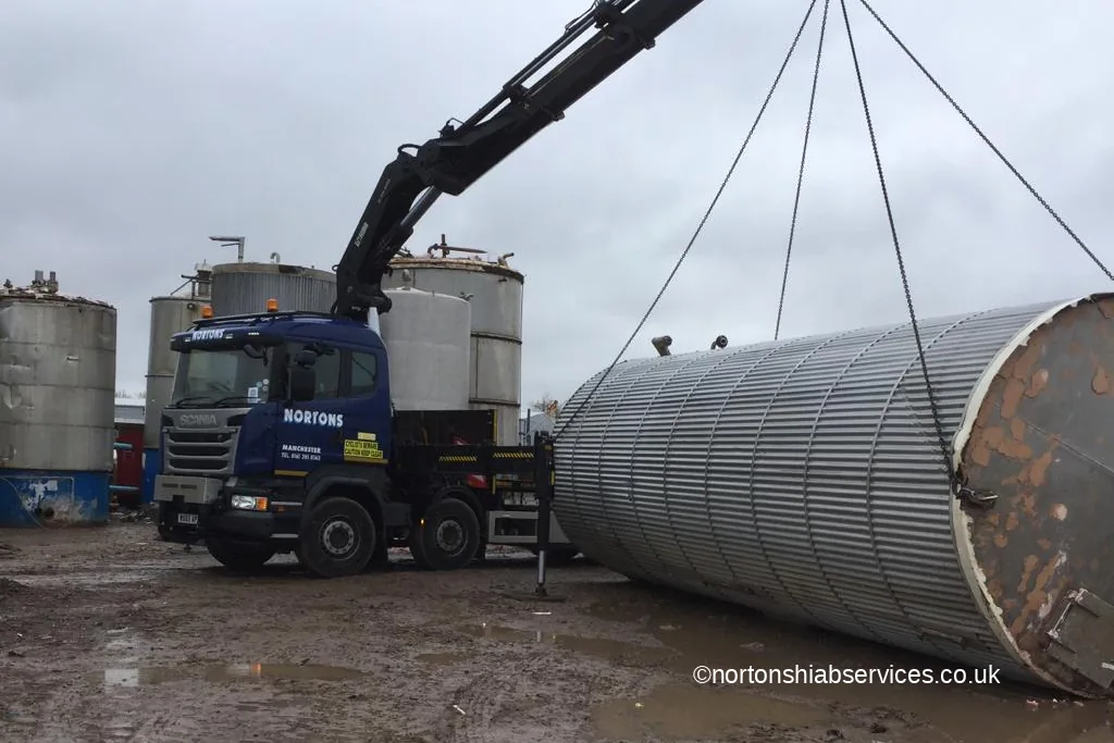 A large steel tank being lowered onto hardstanding by a Nortons hiab