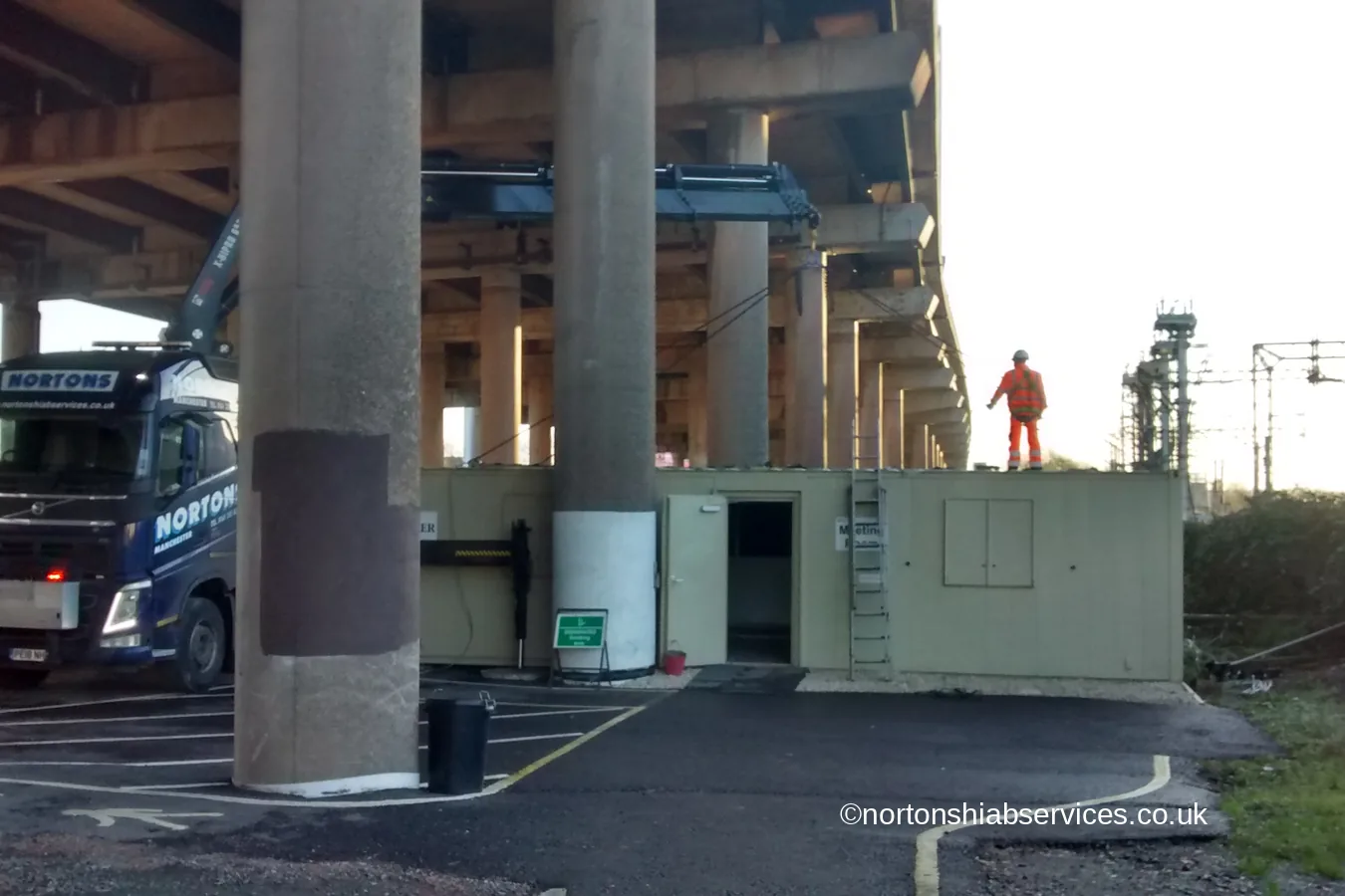 A Nortons hiab lifting a cabin beneath the M5 viaduct at Worcester