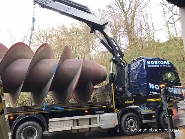 An orange Archimedes screw water turbine loaded on a Nortons trailer
