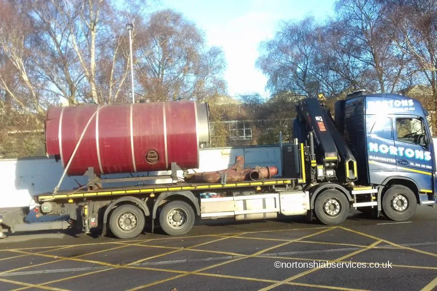 A large red cylindrical boiler chocked and roped on a Nortons flatbed for delivery to Derby